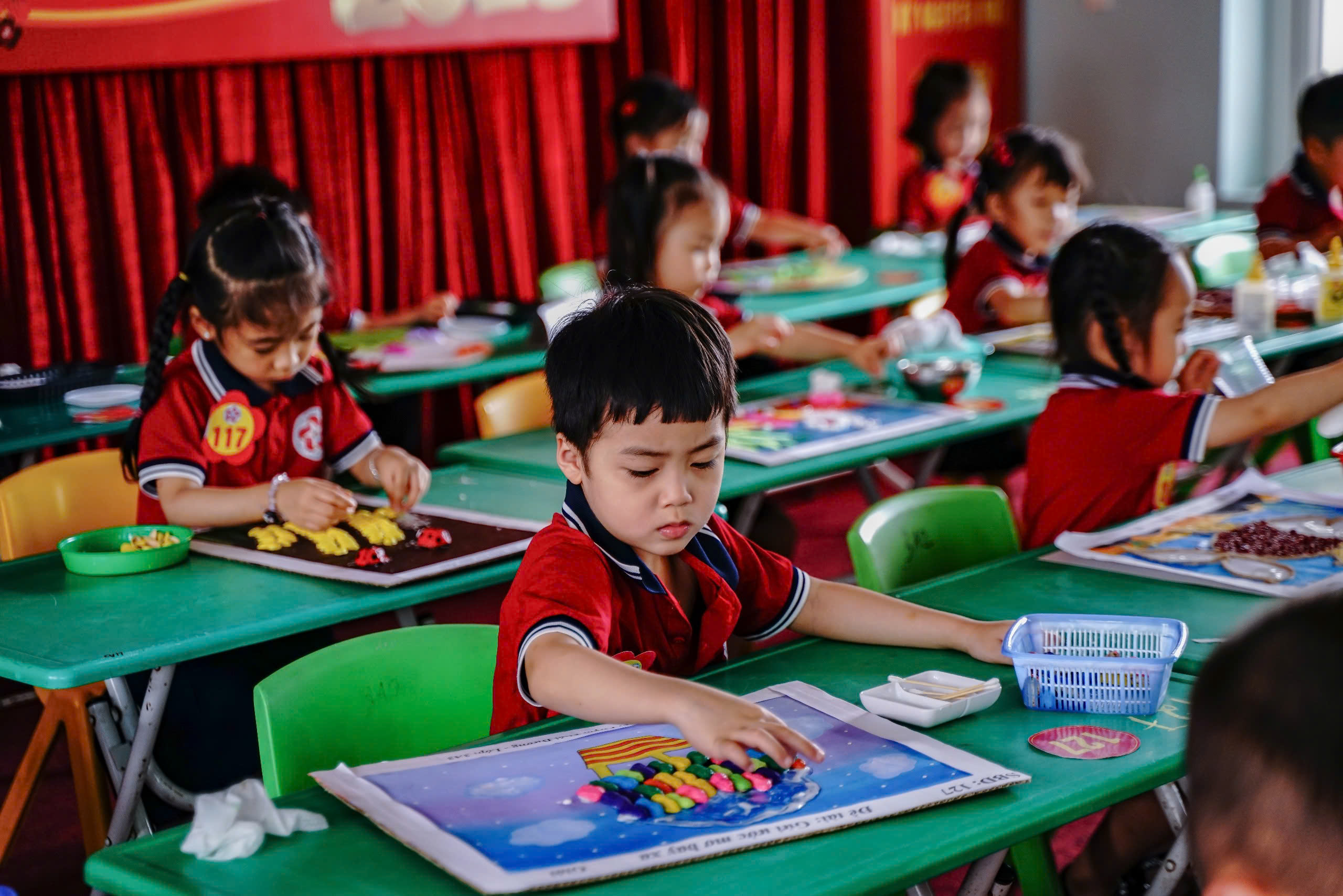 Bạn thì chăm chú sáng tạo với những vỏ lạc sắc màu