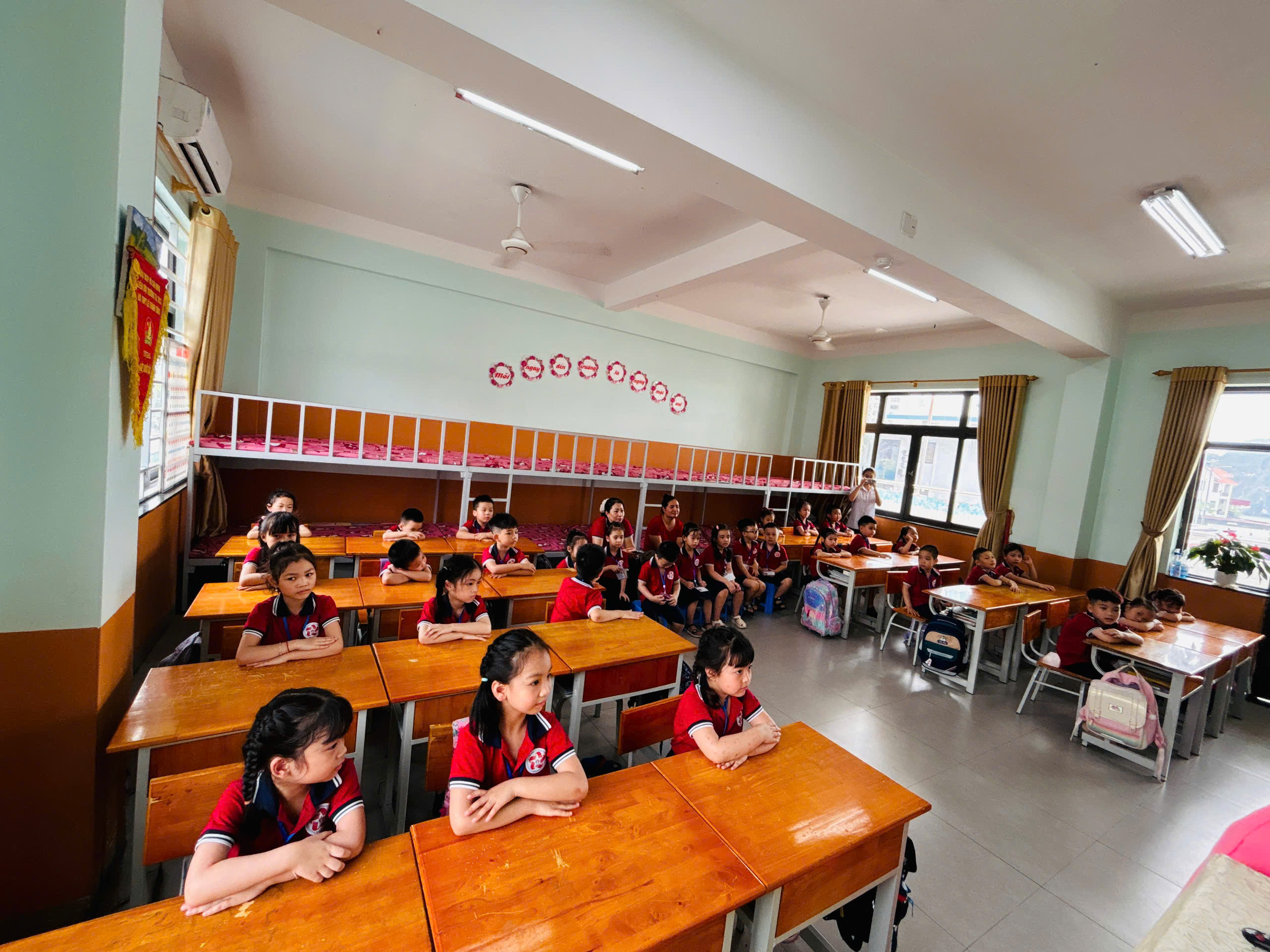 Các bé trải nghiệm ngồi thử bàn học tại lớp của các anh chị lớp 1.